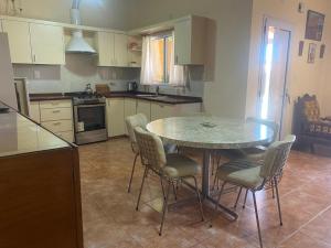 a kitchen with a table and chairs in a kitchen at Cabañas Luna y Sol in Cafayate