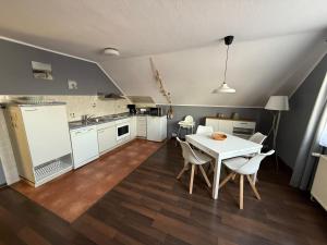 a kitchen with a table and chairs in a room at Strandgut- die Kleine in Dranske