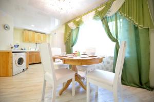 eine Küche mit einem Holztisch und Stühlen sowie einem Fenster in der Unterkunft Five Stars Park Gagarina in Tscheljabinsk