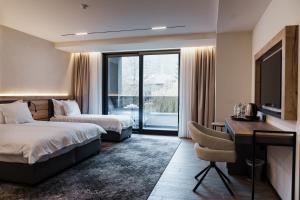 a hotel room with two beds and a desk at Комплекс РАЙ in Ognyanovo