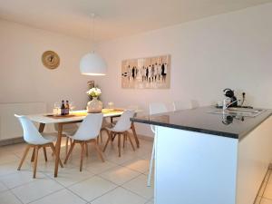 a kitchen and dining room with a table and chairs at Duplex Villa Capricia appartement met zwembad Nieuwpoort Jachthaven in Nieuwpoort