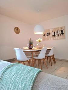 a dining room with a table and white chairs at Duplex Villa Capricia appartement met zwembad Nieuwpoort Jachthaven in Nieuwpoort +40 photos