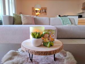 a table with a candle and a doll on it in a living room at Duplex Villa Capricia appartement met zwembad Nieuwpoort Jachthaven in Nieuwpoort