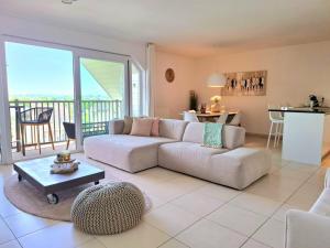 a living room with a couch and a table and a kitchen at Duplex Villa Capricia appartement met zwembad Nieuwpoort Jachthaven in Nieuwpoort