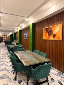 a dining room with tables and green chairs at Gulberg Inn Hotel Lahore in Lahore