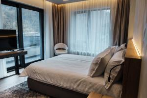 a bedroom with a bed and a large window at Комплекс РАЙ in Ognyanovo