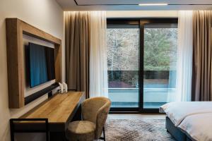 a bedroom with a bed and a desk and a tv at Комплекс РАЙ in Ognyanovo +33 photos