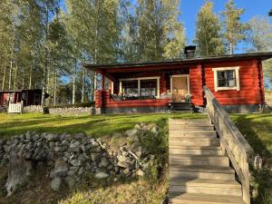 a log cabin in the woods with a wooden walkway at Viihtyisä hirsimökki Venturissa in Siurlahti +14 photos