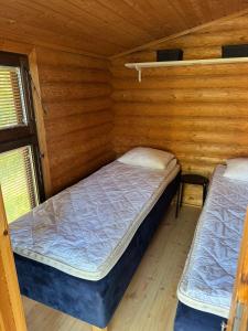 a bedroom with two beds in a wooden cabin at Viihtyisä hirsimökki Venturissa in Siurlahti
