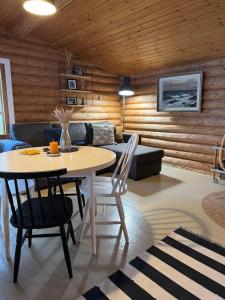 a living room with a table and a couch at Viihtyisä hirsimökki Venturissa in Siurlahti