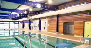 an indoor swimming pool with wooden walls and a swimming pool at Duplex in Escaudain
