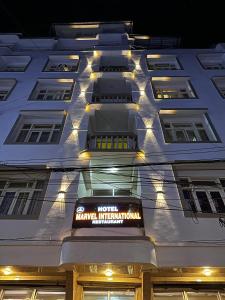 a hotel sign on the side of a building at night at Hotel Marvel International And Restaurant in Darjeeling