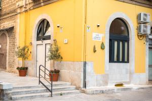 a yellow building with two arched doors and stairs at Desideri di Puglia in Barletta