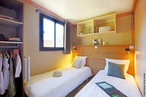 a bedroom with two beds and a window at Camping Les Lavandes in Darbres