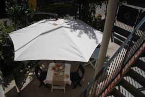 Pilzone的住宿－Casa del Nespolo，一张桌子和椅子上的白色遮阳伞