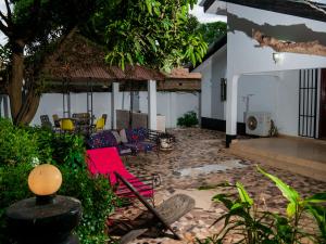 a patio of a house with red chairs and a table at Bougan Villa in Brufut