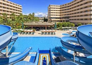 a pool at a resort with chairs and a slide at Özkaymak Incekum Resort - Ultra All Inclusive in Avsallar