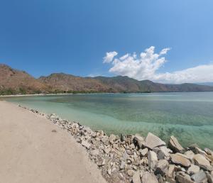 a view of a beach with rocks and the water at Vila Bemori in Dili