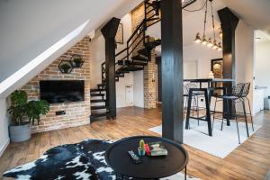 a loft apartment with a brick wall and a spiral staircase at Promenada Apartmani Zlatibor in Zlatibor