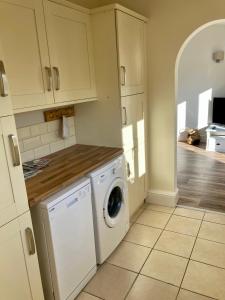 a kitchen with a washer and dryer in it at The Stables in Metheringham +13 photos