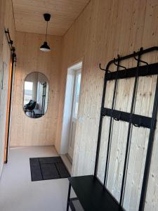 a room with a wooden wall with a mirror at New listing - Krosshóll Cottage, built in 2026 in Hella
