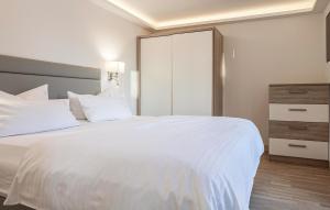 a bedroom with a large white bed and a dresser at Garden Suite in Binz