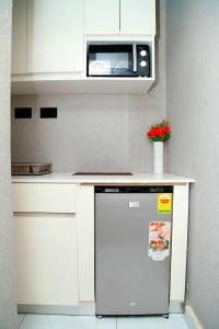a small kitchen with a microwave and a refrigerator at Petite's Nest - Apartment 5 in Accra