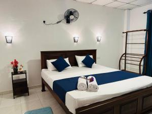 a bedroom with a bed with two towels on it at Looma House Hiriketiya in Dickwella