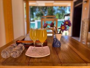 two glasses of wine sitting on a wooden table at Looma House Hiriketiya in Dickwella