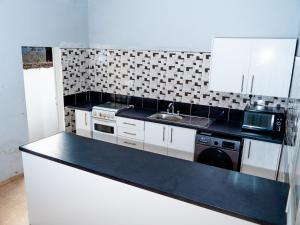 a kitchen with a black counter top and a sink at Bougan Villa in Brufut +5 photos