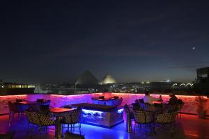 a patio with tables and chairs at night at Delta Pyramids Hotel in Giza