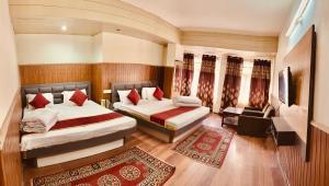 a hotel room with two beds and a couch at Hotel Marvel International And Restaurant in Darjeeling +8 photos