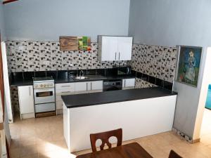 a kitchen with black and white tile on the wall at Bougan Villa in Brufut