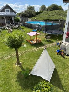 a tent in a yard next to a tree at Kwiatowe Domki in Rogowo