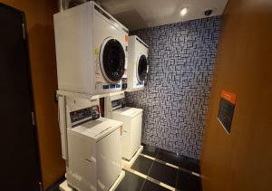 a small laundry room with a washer and dryer at APA Hotel Ayase Ekimae in Tokyo