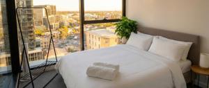 a bedroom with a white bed and a large window at Domain House Executive in Melbourne