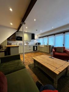 a living room with a couch and a wooden table at Little House Annexe in Shotteswell