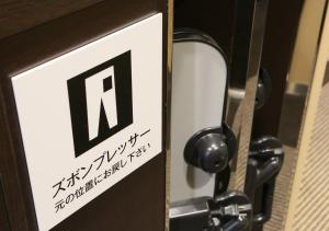 a sign on a door with the letter n on it at APA Hotel Ayase Ekimae in Tokyo