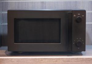 a black microwave oven sitting on top of a table at APA Hotel Ayase Ekimae in Tokyo +38 photos