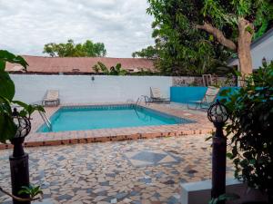 a swimming pool with two chairs next to at Bougan Villa in Brufut