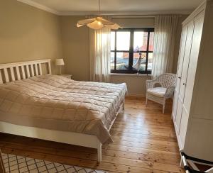 a bedroom with a bed and a window and a chair at Ferienhaus Elbblick in Tangermünde