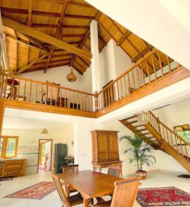 a living room with a wooden table and a staircase at Luxury Cannelle lake villa in Hikkaduwa