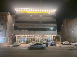 a parking lot with cars parked in front of a building at إيلاف للشقق المخدومة in Buraydah