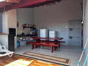 a dining room with a wooden table and a bench at Casa de Férias com Piscina in Salinópolis
