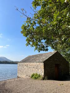 a stone building sitting next to a body of water at West Cumbria static caravan in Workington
