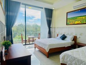 a hotel room with two beds and a large window at New Day Tuy Hòa in Liên Trì (4)