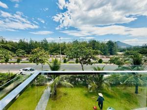 a man standing on a balcony looking out at a street at New Day Tuy Hòa in Liên Trì (4)