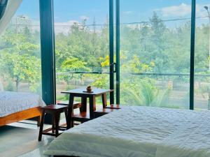 a bedroom with a bed and a table and a large window at New Day Tuy Hòa in Liên Trì (4) +8 photos