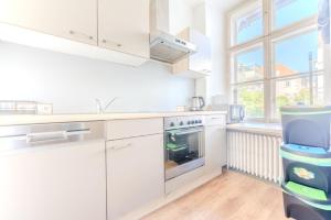 a kitchen with white cabinets and a stove top oven at Stadtwohnung im Zentrum in Größing