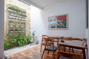 a room with tables and chairs and a painting on the wall at Omah Ninten Syariah Laweyan RedPartner in Solo